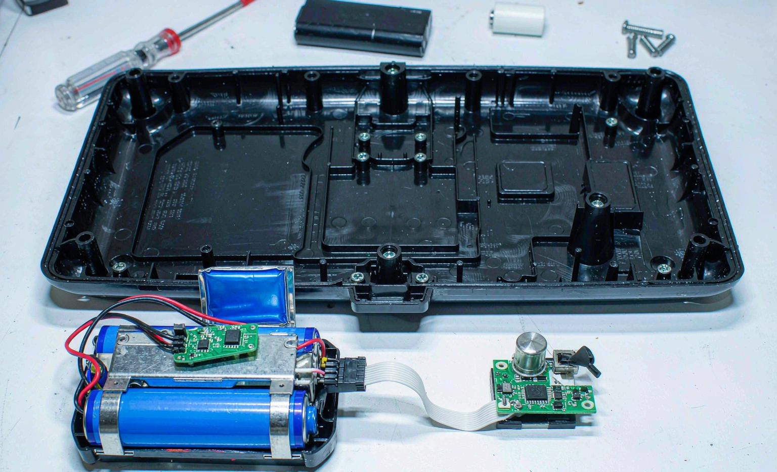 Custom lithium battery pack powering a wireless IoT sensor node on an engineer workbench
