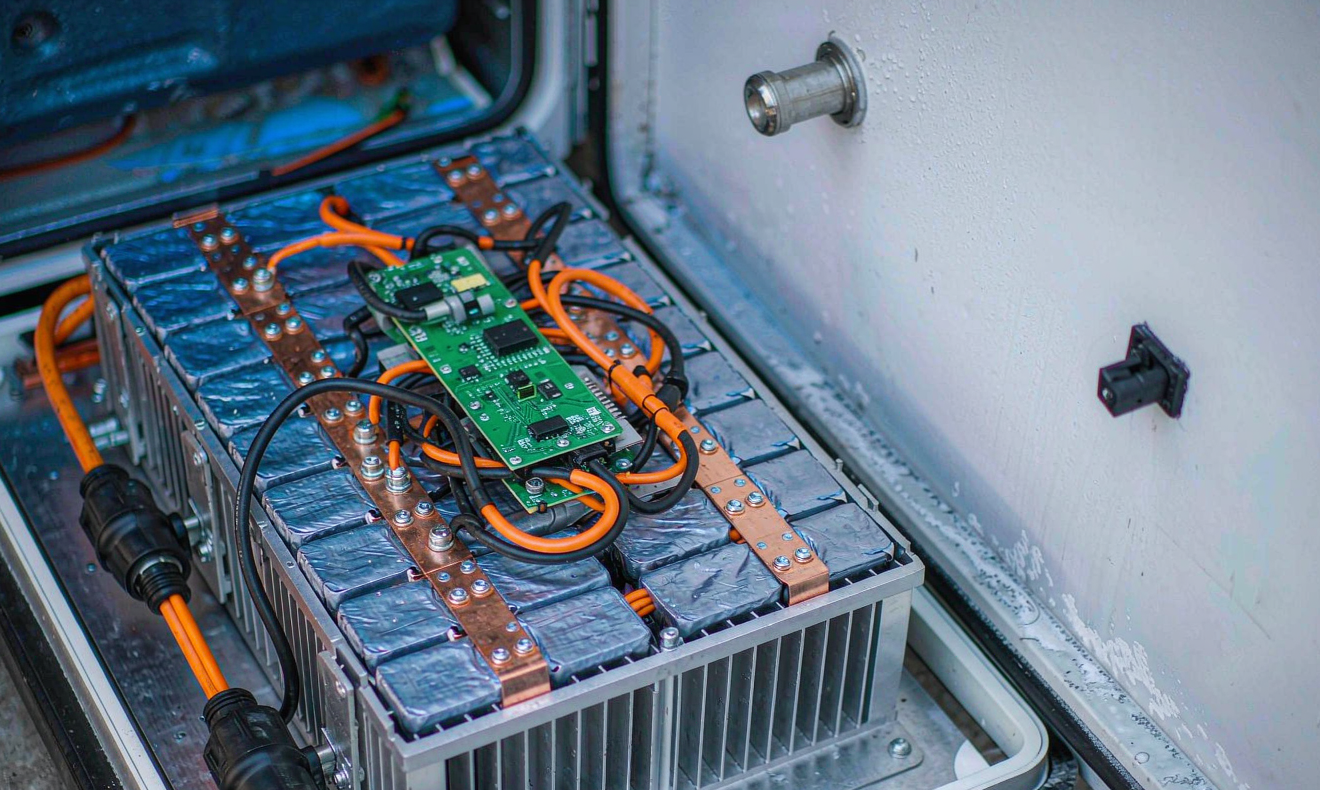 Open lithium battery pack for a refrigerated transport unit showing prismatic LFP cells, copper busbars, BMS board and IP67 connectors