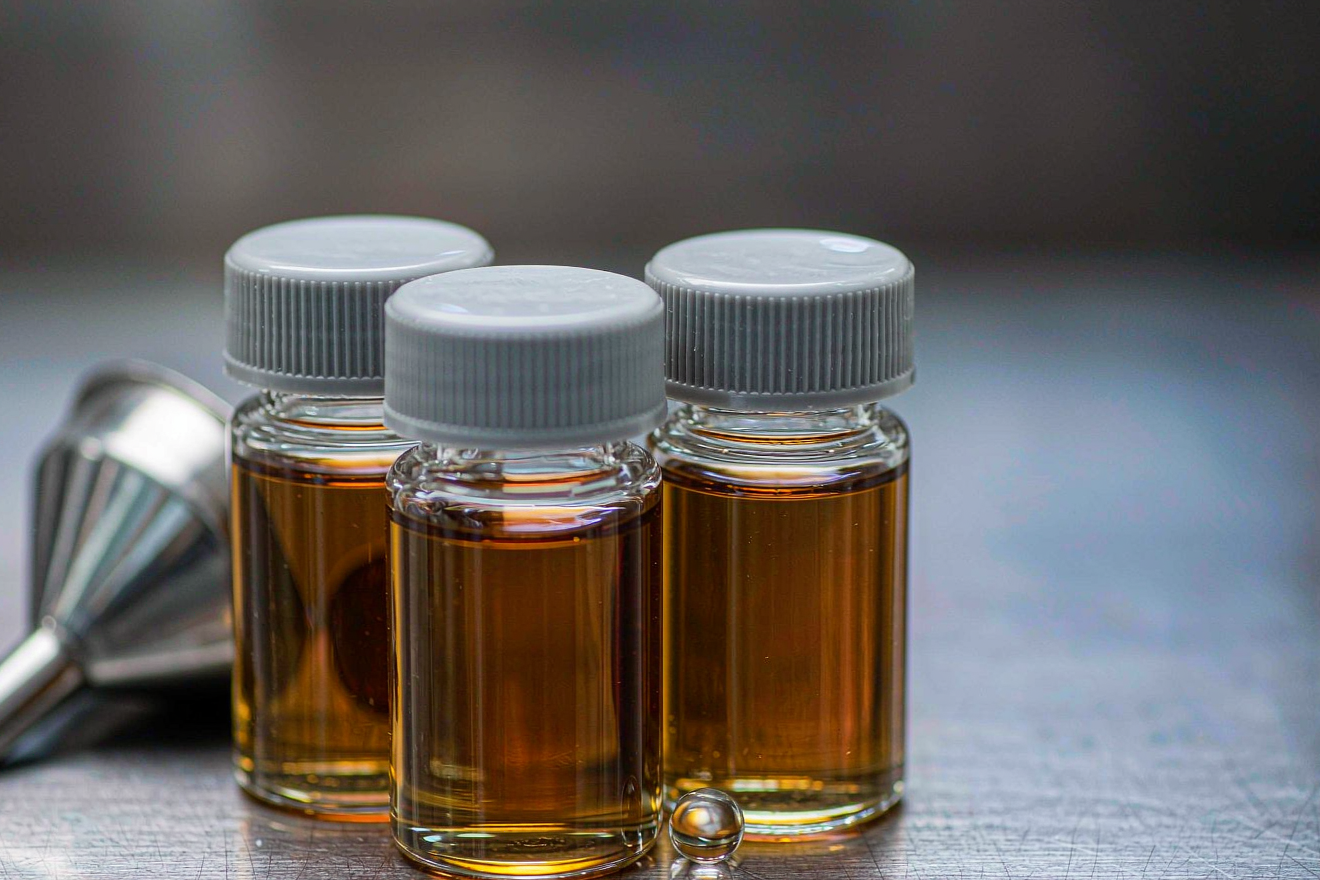 Sodium-ion battery electrolyte salt selection: amber electrolyte bottles on a stainless steel bench