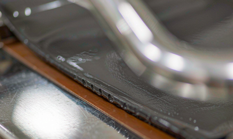 Sodium-ion battery water-based electrode processing: wet dark electrode slurry spread onto copper foil by a stainless steel coating bar