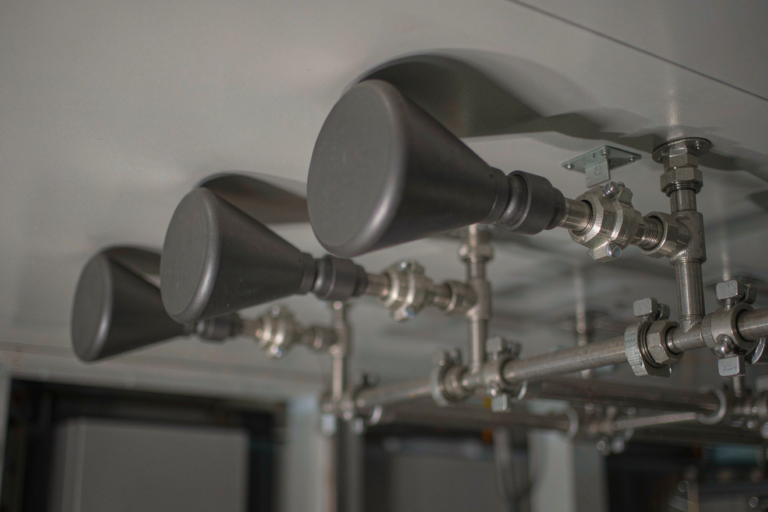 Sodium-ion battery fire suppression nozzles and pipe manifold mounted on a battery room ceiling